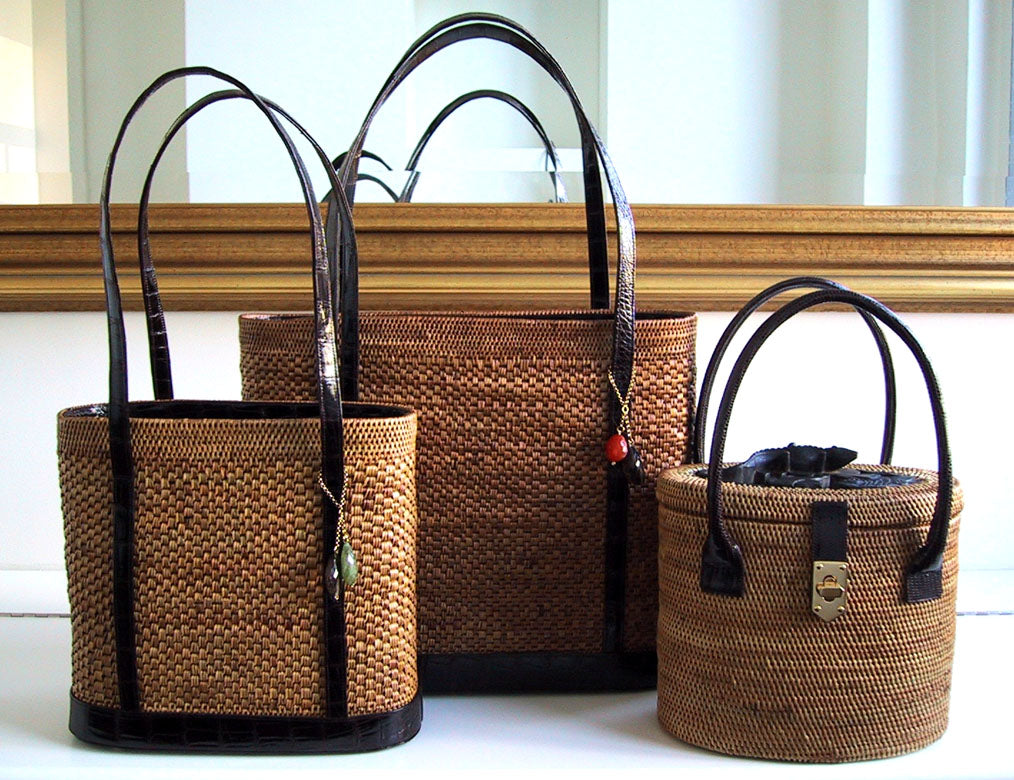 Three woven bags with exotic skin handles on a desk - Darby Scott