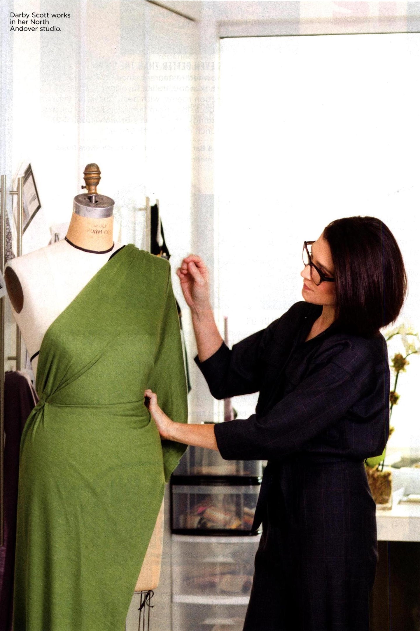 Darby Scott draping fabric on a mannequin, workign on a dress design.