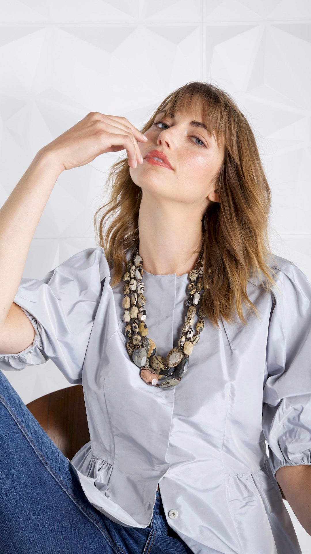 Model wearing a Darby Scott peplum taffeta top and three strand leopard jasper necklace