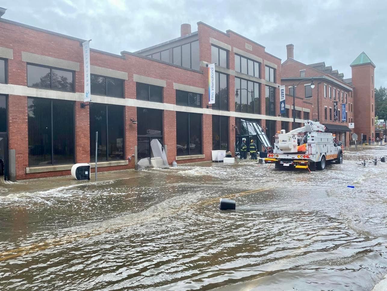 Flooded High Street N. Andover. Damaged Mill buildings and debris in the street.