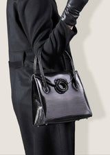 A Thompson "O" Tote in Black Lizard on the arm of a model - Darby Scott