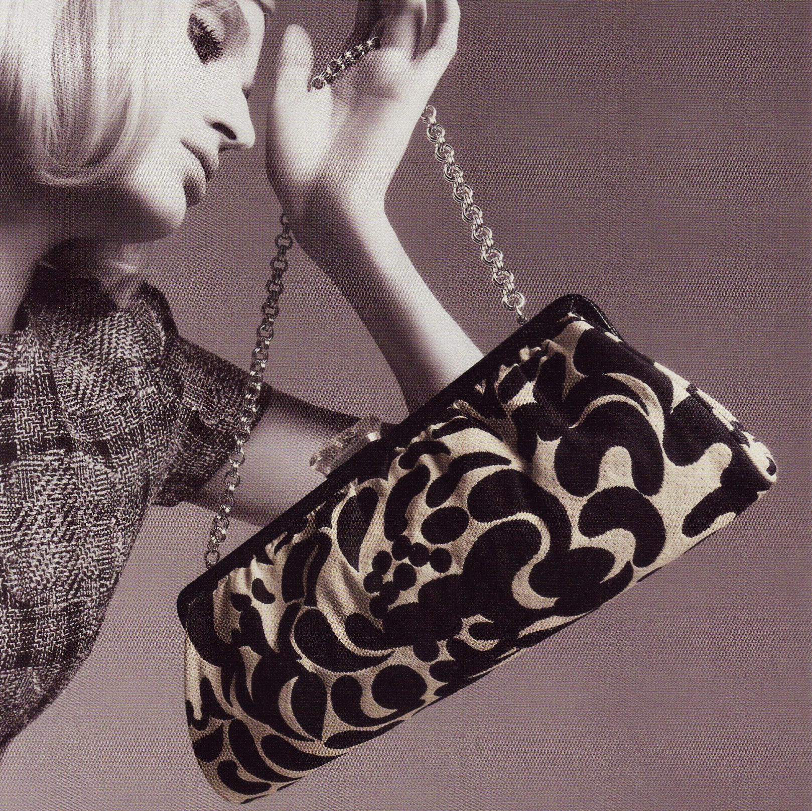 Model holding brocade long clutch by Darby Scott