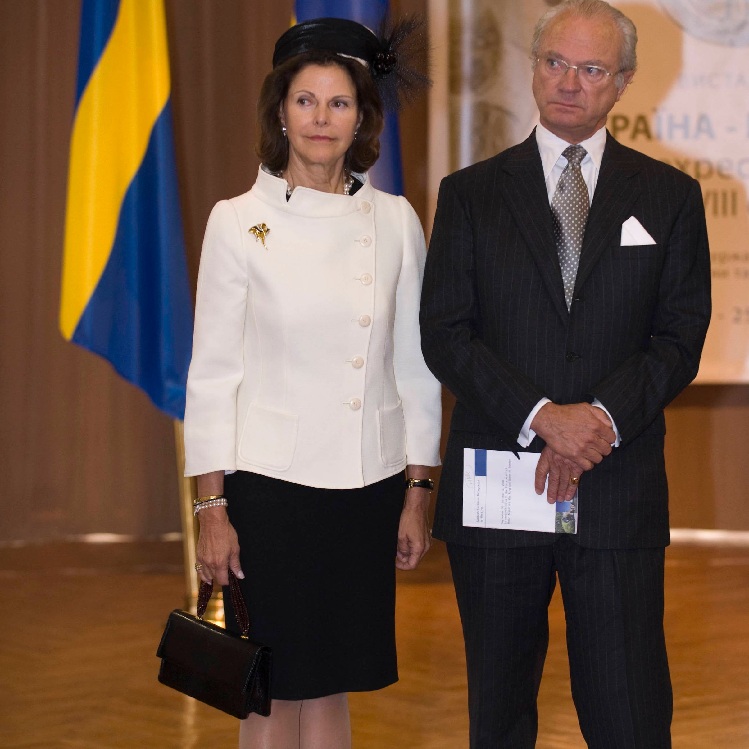 Queen Silvia & King Carl XVI Gustaf of Sweden at National Museum in Kiev, October 2008. The queen carries a Darby Scott jeweled handbag. 