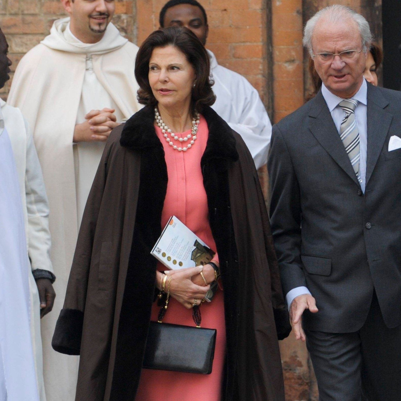 Queen Silvia & King Carl XVI Gustaf of Sweden in Italy. Queen carries a Darby Scott Iconic Handbag