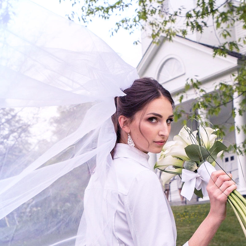 Bride holding a bouquet in front of a church - Darby Scott 