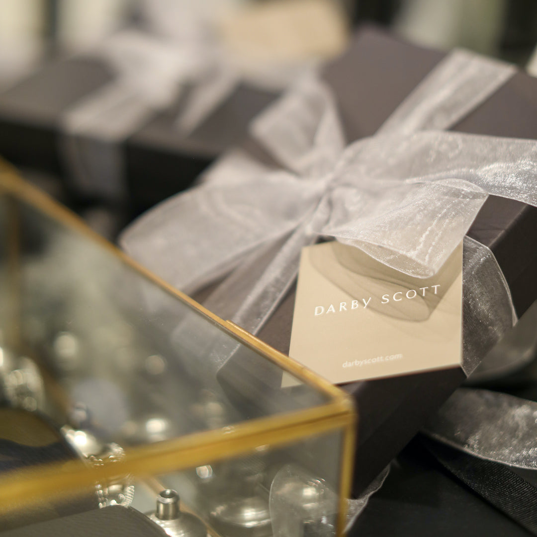 Product packaging with 'Darby Scott' branding on a glass surface.