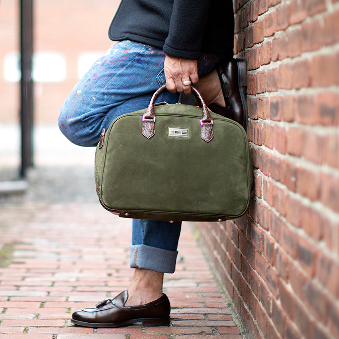 Man holding Newport Carry-on in green suede
