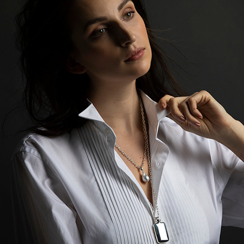 Model wearing a sterling silver perfume pendant and a pearl pendant - Darby Scott