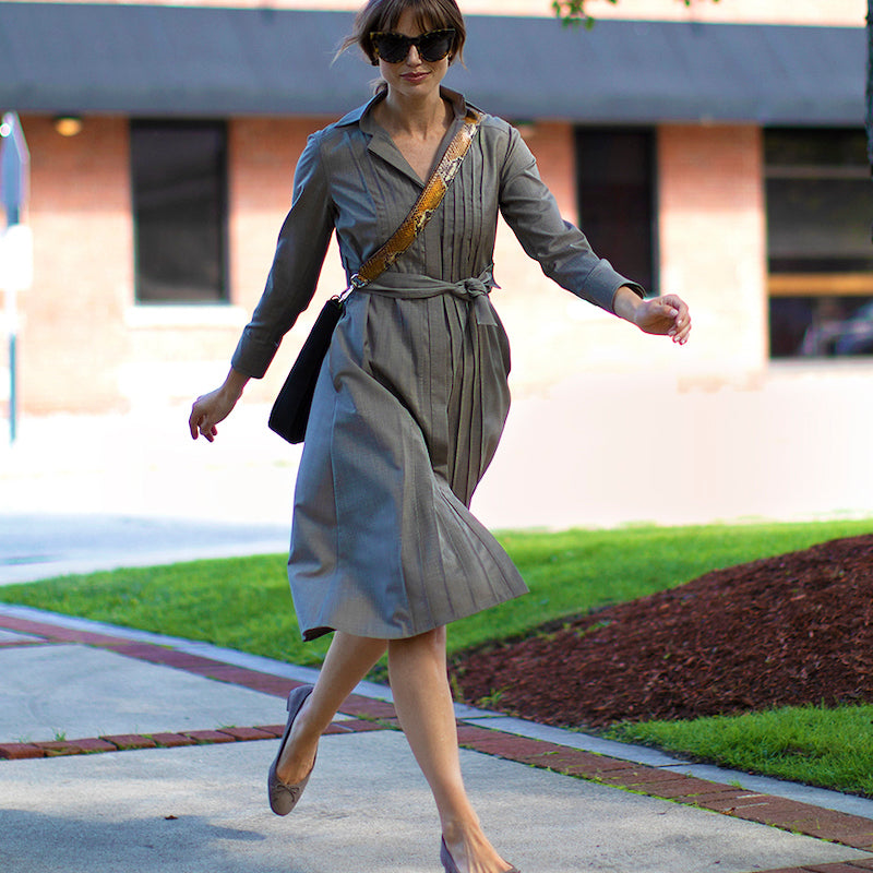 Woman in shirt dress running on the sidewalk