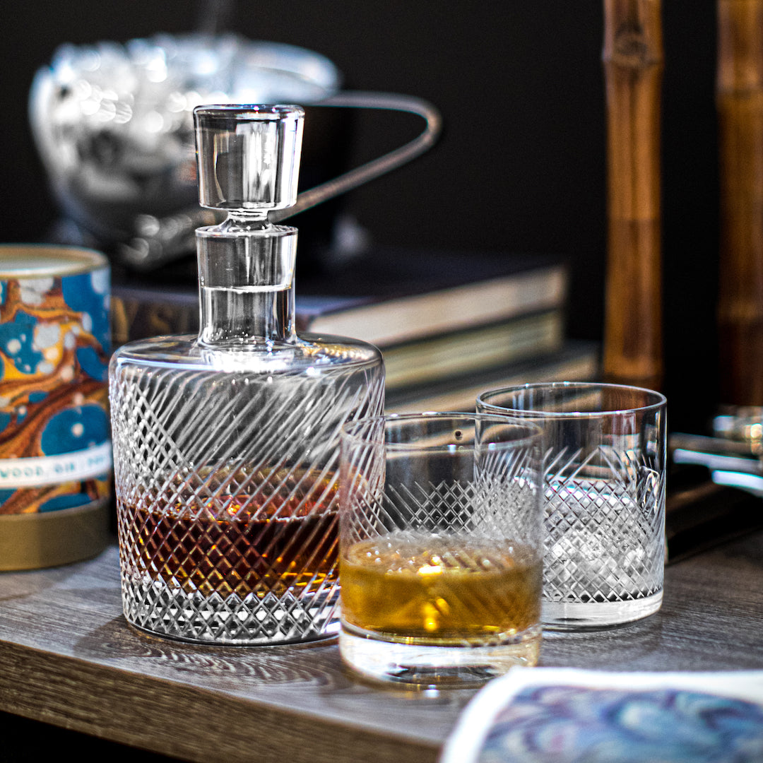 Cut glass decanter, rocks glasses on tabletop