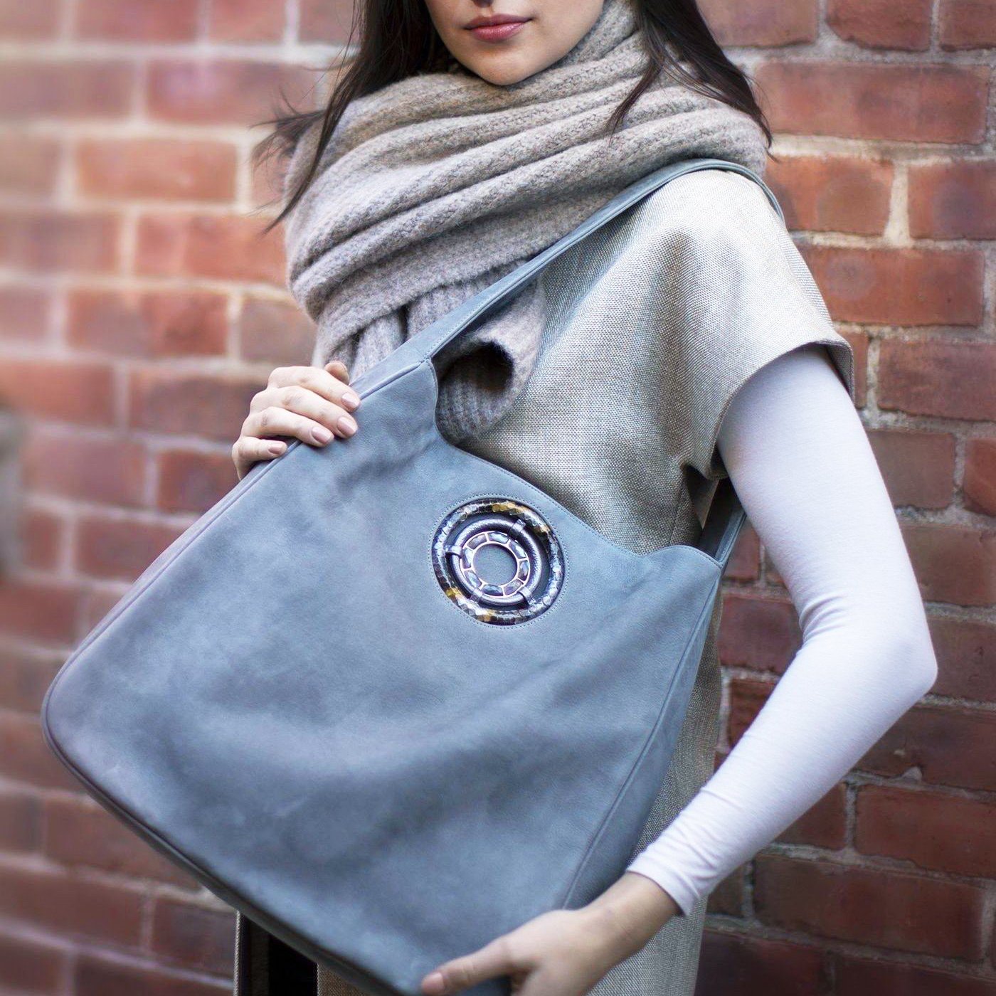 Model holding denim blue paige hobo bag - Darby Scott