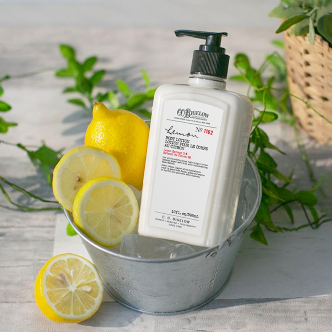 Bottle of lemon body lotion in ice bucket with lemon slices