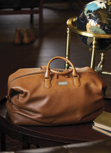 Leather Aspen Travel Bag in front of a globe in an office setting - Darby Scott