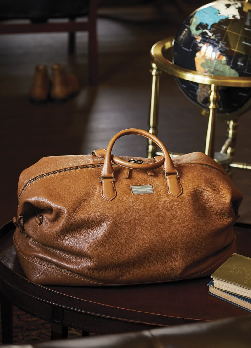 Leather Aspen Travel Bag in front of a globe in an office setting - Darby Scott