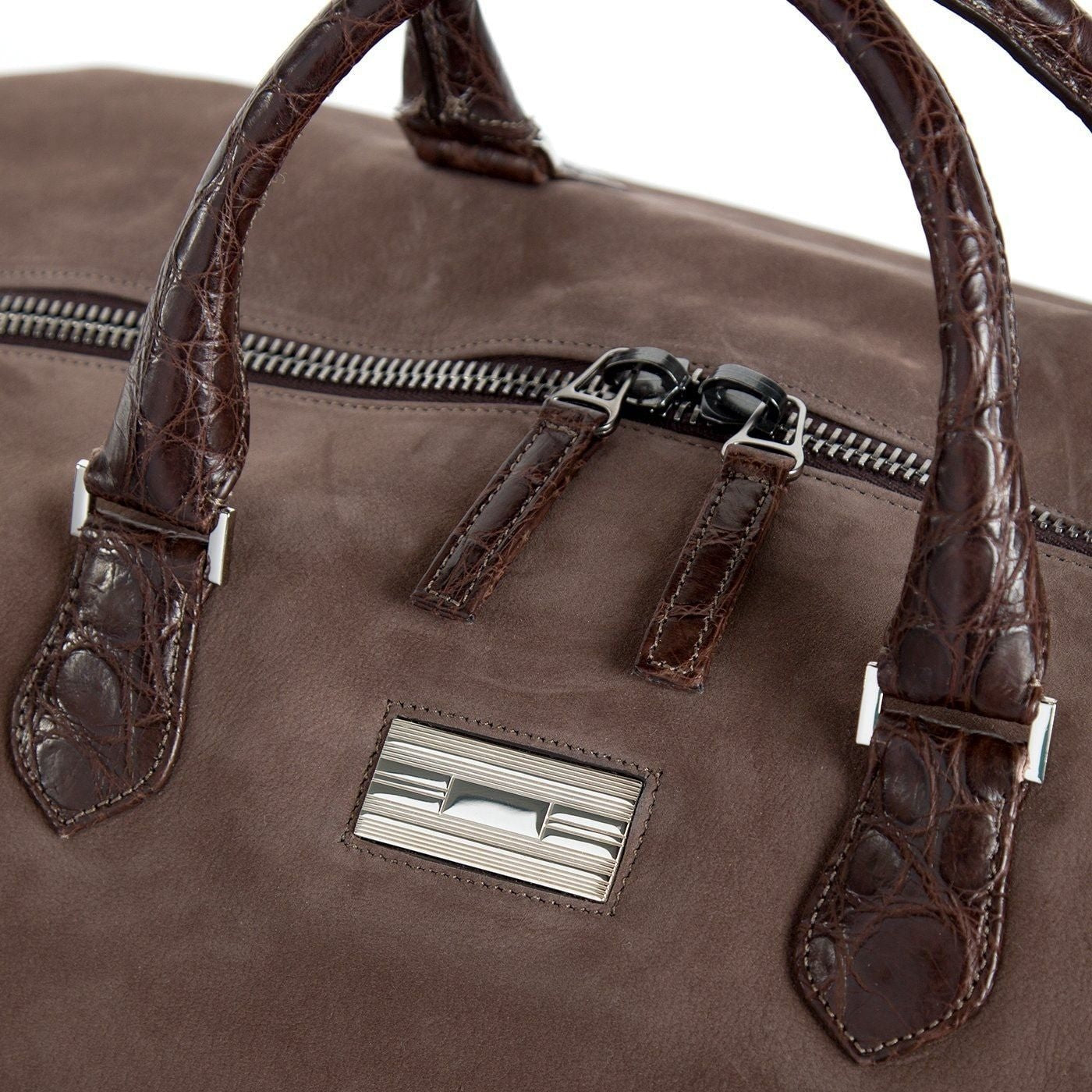 Close up of sterling silver monogram plate on light brown suede Aspen Travel Bag - Darby Scott