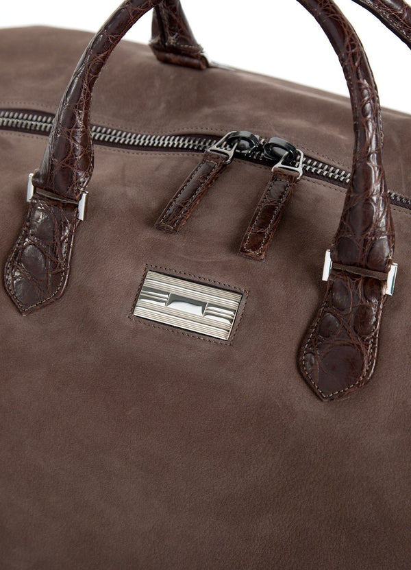 Close up of sterling silver monogram plate on light brown suede Aspen Travel Bag - Darby Scott